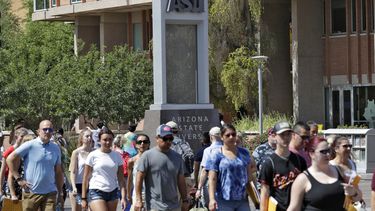 ARCHIVO - Transeúntes caminan en el campus de la Universidad Estatal de Arizona en Tempe, Arizona, el 25 de julio de 2018. (AP Foto/Matt York, Archivo)