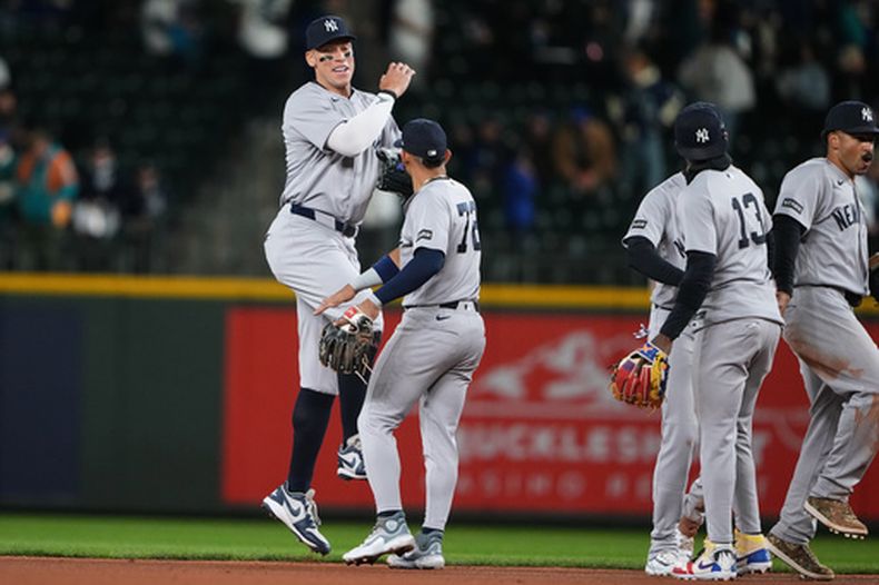 Aaron Judge (izquierda), de los Yankees de Nueva York, festeja con el panameño José Caballero tras la victoria sobre los Marineros de Seattle, el martes 31 de marzo de 2026 (AP Foto/Lindsey Wasson)