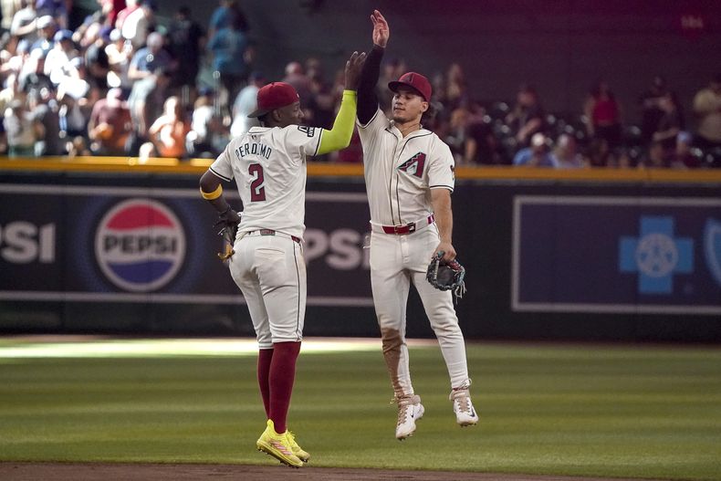 Geraldo Perdomo (2) y Alek Thomas, a la derecha, de los Diamondbacks de Arizona, celebran su victoria por 12-5 sobre los Filis de Filadelfia el domingo 11 de agosto de 2024, en Phoenix. (AP Foto/Darryl Webb)