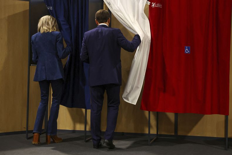 El presidente francés Emmanuel Macron y su esposa Brigitte Macron entran en una cabina de votación durante las elecciones europeas, el domingo 9 de junio de 2024 en Le Touquet-Paris-Plage, al norte de Francia. (Hannah McKay/Pool vía AP)