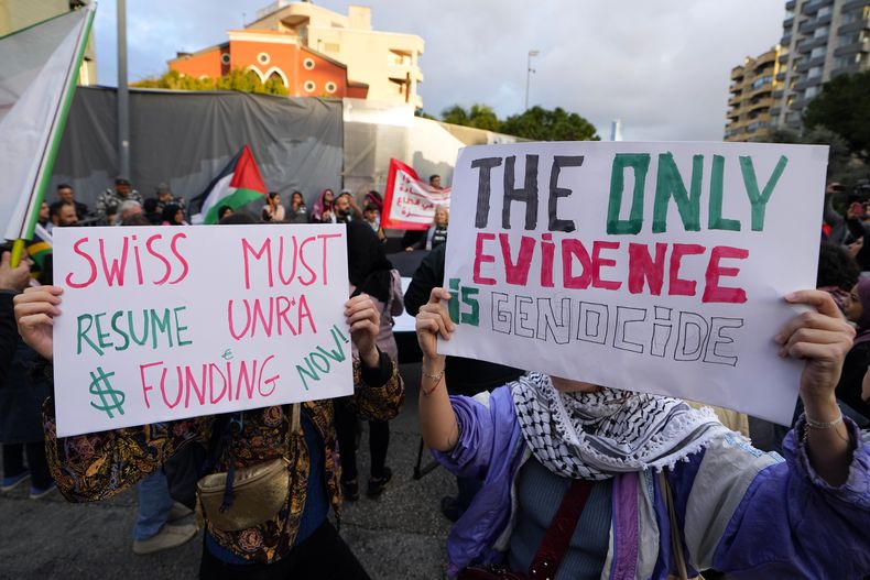 Activistas sostienen letreros durante una protesta para exigir que los países retomen el envío de fondos a la UNRWA y apoyen a los palestinos de la Franja de Gaza, cerca de la sede de la Unión Europea, en Beirut, Líbano, el miércoles 7 de febrero de 2024. (AP Foto/Bilal Hussein)