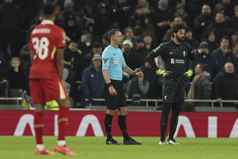 El árbitro Stuart Attwell junto al arquero de Liverpool Alisson durante la ida de las semifinales de la Copa de la Liga inglesa contra Tottenham, el miércoles 8 de enero de 2025. (AP Foto/Ian Walton)