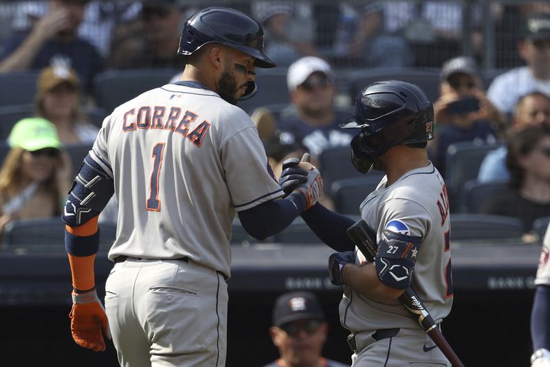 Carlos Correa, izquierda, de los Astros de Houston y José Altuve, derecha, reaccionan después de que Correa pegara un cuadrangular durante la novena entrada del juego de béisbol en contra de los Yankees de Nueva York, el domingo 10 de agosto de 2025, en Nueva York. (AP Foto/Pamela Smith)