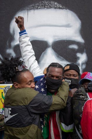 Los residentes locales Mileesha Smith, Michael Wilson y Alfonzo Williams se abrazan después del veredicto en el juicio del ex oficial de policía de Minneapolis Derek Chauvin, declarado culpable de la muerte de George Floyd, en George Floyd Square en Mi
