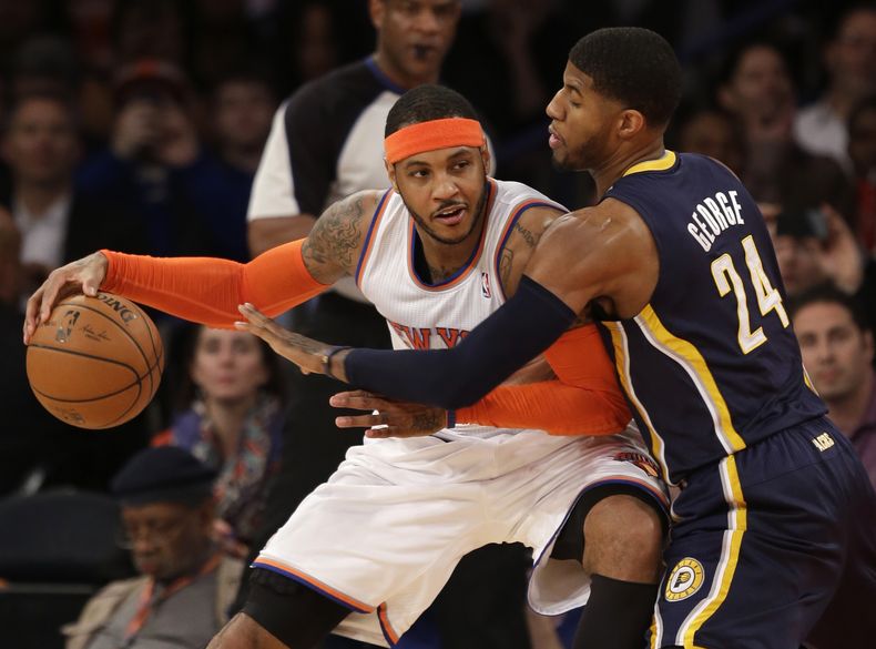 Carmelo Anthony (izquierda), de los Knicks de Nueva York, trata de superar la marca de Paul George, de los Pacers de Indiana, durante la primera mitad de su partido de basquetbol disputado el mi&eacute;rcoles 19 de marzo de 2014 en Nueva York. (Foto AP/Se