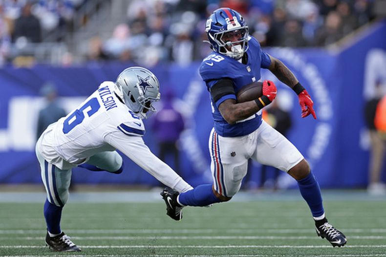 ARCHIVO - Foto del 4 de enero del 2026, el corredor de los Giants de Nueva York Tyrone Tracy Jr. corre con el balón superando al safety de los Cowboys de Dallas Donovan Wilson. (AP Foto/Adam Hunger, Archivo)