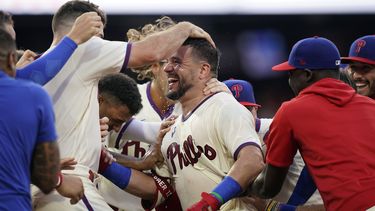 Kyle Schwarber de los Filis de Filadelfia celebra con sus compañeros tras batear el elevado de sacrificio ante el relevista de los Padres de San Diego Tim Hill en la 12ma entrada del juego del domingo 16 de julio del 2023. (AP Foto/Matt Slocum)