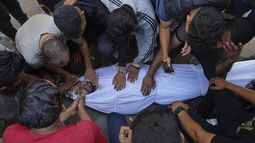 Familiares lloran sobre el cuerpo del palestino Bilal Abu Amsha, asesinado con otras personas en ataques aéreos israelíes en la Franja de Gaza, en el hospital de Al-Shifa en Ciudad de Gaza, el sábado 28 de junio de 2025. (AP Foto/Jehad Alshrafi)