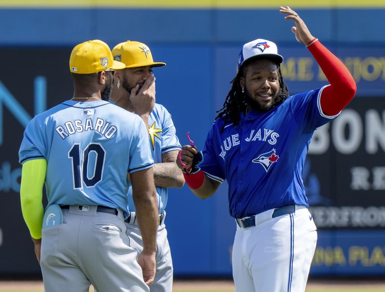 Vladimir Guererro Jr. de los Azulejos de Toronto comparte un momento con Amed Rosario y José Siri de los Rays de Tampa Bay durante los entrenamientos de primavera el miércoles 28 de febrero del 2024. (Frank Gunn/The Canadian Press via AP)