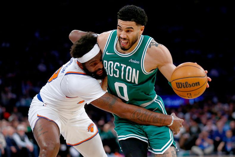 Mitchell Robinson, izquierda, de los Knicks de Nueva York, intenta robarle el balón a Jayson Tatum, de los Celtics de Boston, durante la segunda mitad del juego de baloncesto de la NBA, el jueves 9 de abril de 2026, en Nueva York. (AP Foto/John Munson)