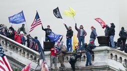 ARCHIVO - Manifestantes agitan banderas en el frente oeste del Capitolio de Estados Unidos en Washington el 6 de enero de 2021. (AP foto/Jose Luis Magana, archivo)