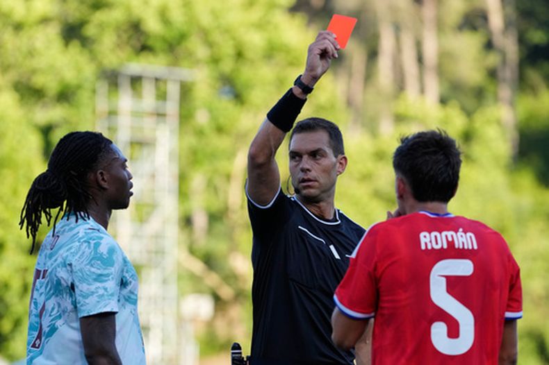 El árbitro Luca Zufferli muestra tarjetas rojas a Rafael Leão de Portugal (izquierda) y a Iván Román de Chile durante un partido de fútbol amistoso internacional entre Portugal y Chile en Oeiras, a las afueras de Lisboa, el sábado 6 de junio de 2026. (Foto AP/Armando Franca)