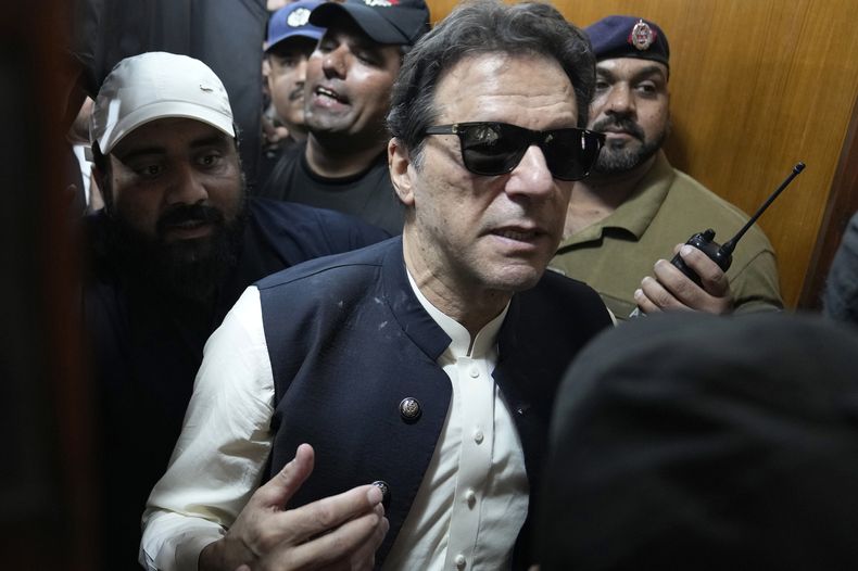El ex primer ministro de Pakistán Imran Khan, centro, sale de una corte tras comparecer en Lahore, Pakistán, el viernes 19 de mayo de 2023. El ex primer ministro de Pakistán Imran Khan continuaba el martes 23 de mayo de 2023 con su batalla legal ante una corte de la capital, Islamabad, que le concedió protección ante un arresto hasta principios del mes que viene en varios casos en los que se le acusa de terrorismo por incitar a la violencia. (AP Foto/K.M. Chaudary)