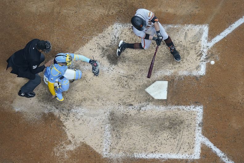 J.D. Davis, de los Gigantes de San Francisco, batea un jonrón de dos carreras en el séptimo capítulo del juego ante los Cerveceros de Milwaukee, el viernes 26 de mayo de 2023 (AP Foto/Morry Gash)
