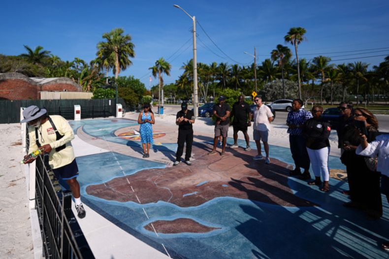 Addeliar Guy, de Underwater Adventure Seekers, de 74 años, vierte ron blanco sobre la arena en un memorial donde están enterrados cientos de africanos que murieron en 1860 en un barco de comercio de esclavos, en Higgs Beach, en Cayo Hueso, Florida, el 9 de mayo de 2026. (Foto AP/Rebecca Blackwell)