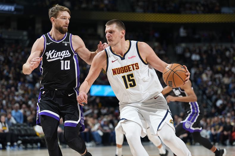El pívot de los Nuggets de Denver Nikola Jokic (derecha) conduce para rebasar al ala-pívot de los Kings de Sacramento Domantas Sabonis, durante la 2da mitad del juego de baloncesto de la NBA, el miércoles 28 de febrero de 2024, en Denver. (AP Foto/David Zalubowski)