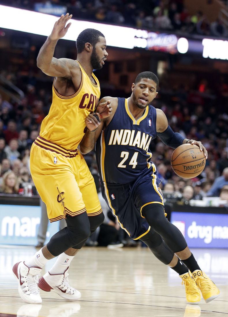 Paul George (24), de los Pacers de Indiana, ataca la defensa de Earl Clark, de los Cavaliers de Cleveland, en el primer cuarto del juego del domingo 5 de enero de 2014, en Cleveland. (Foto AP/Tony Dejak)