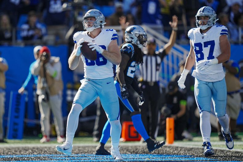 El tight end Luke Schoonmaker, izquierda, de los Cowboys de Dallas, celebra después de anotar n touchdown en contra de los Panthers de Carolina durante la primera mitad del juego de la NFL, el domingo 19 de noviembre de 2023, en Charlotte, Carolina del Norte. (AP Photo/Rusty Jones)