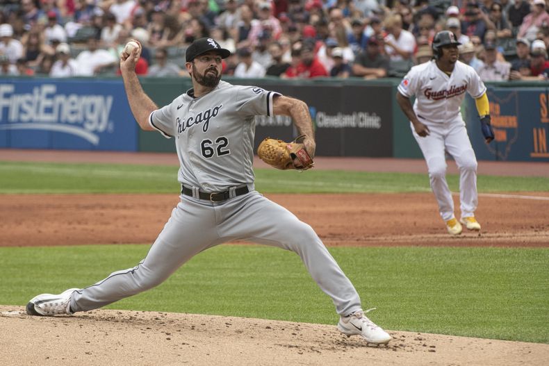 Jesse Scholtens de los Medias Blancas de Chicago lanza mientras José Ramírez de los Guardianes de Cleveland aguarda en la primera base, el domingo 6 de agosto de 2023. (AP Foto/Phil Long)