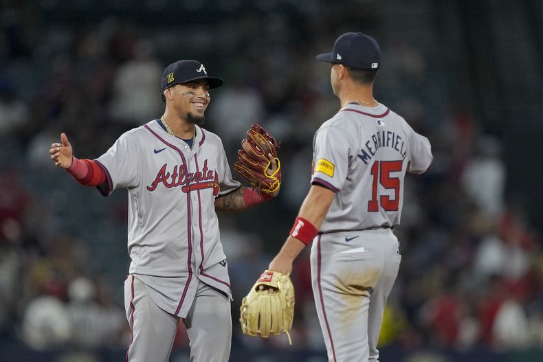 El campocorto de los Bravos de Atlanta, Orlando Arcia, a la izquierda, y el segunda base Whit Merrifield celebran después de la victoria del equipo contra los Angelinos de Los Ángeles, el sábado 17 de agosto de 2024, en Anaheim, California (AP Foto/Ryan Sun)