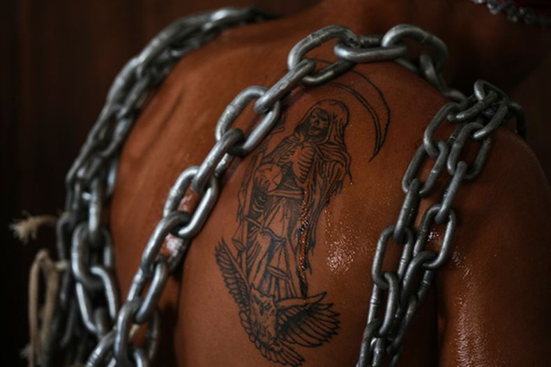 Cadenas cubren el tatuaje de la Santa Muerte de un penitente antes de una procesión del Viernes Santo durante la Semana Santa, el viernes 3 de abril de 2026, en Atlixco, México. (AP Foto/Fernando Llano)