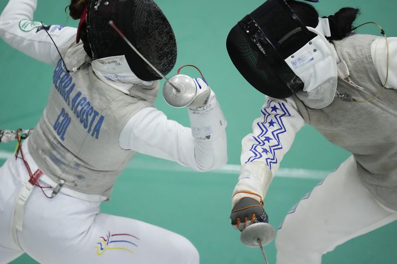 La colombiana Laura Guerra combate con la hondureña Angie Mejía en la esgrima con floretes, durante los Juegos Centroamericanos y del Caribe, el domingo 2 de julio de 2023 (AP Foto/Arnulfo Franco)