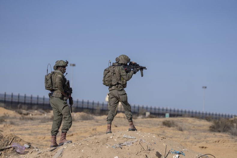 Soldados israelíes apuntan con un arma al montar guardia en el laso palestino del cruce fronterizo de Kerem Shalom durante un recorrido de periodistas por el área de la Franja de Gaza, el jueves 19 de diciembre de 2024. (AP Foto/Ohad Zwigenberg)