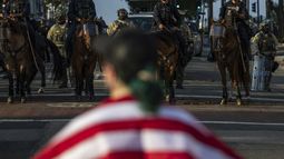Agentes de policía, frente a manifestantes en el exterior del edificio del ayuntamiento durante protestas contra las redadas migratorias federales, el 11 de junio de 2025, en Los Ángeles. (AP Foto/Ethan Swope)