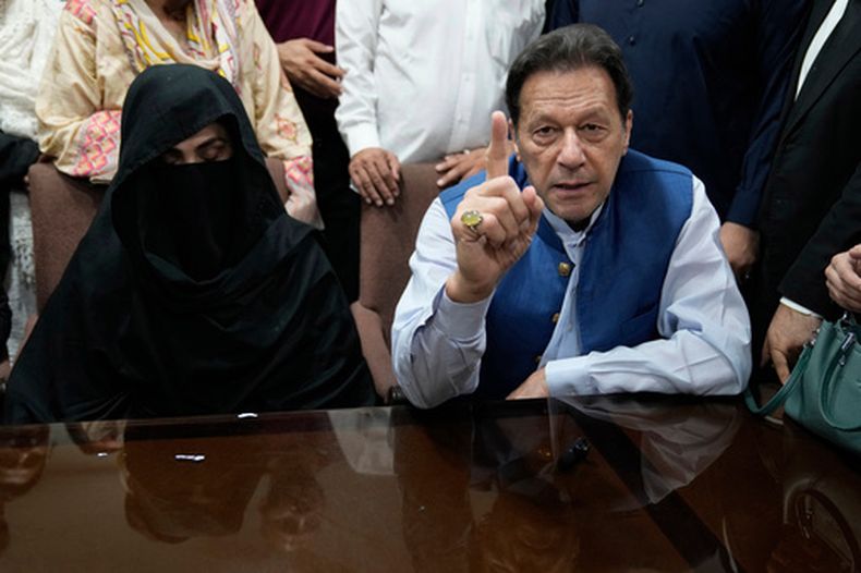 ARCHIVO - El ex primer ministro de Pakistán, Imran Khan, derecha, y Bushra Bibi, su esposa, hablan con los medios antes de firmar documentos para presentar una fianza en diferentes casos, en una oficina del Tribunal Superior de Lahore, Pakistán, el 17 de julio de 2023. (Foto AP/K.M. Chaudary, archivo)