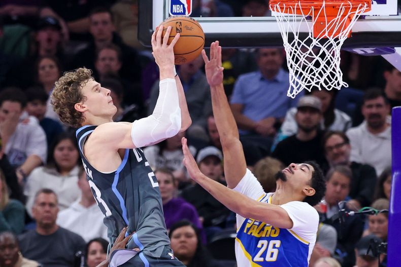 El finlandés Lauri Markkanen, del Jazz de Utah, salta hacia la cesta frente a Ben Sheppard, de los Pacers de Indiana, el martes 11 de noviembre de 2025 (AP Foto/Rob Gray)