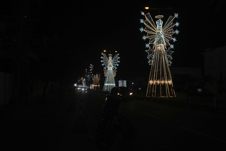 Coches pasan junto a decoraciones navideñas en una calle de Lagos, Nigeria, el viernes 20 de diciembre de 2024. (AP foto/Sunday Alamba)