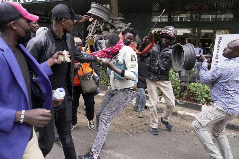 Un presunto partidario del gobierno es atacado por manifestantes en una protesta por la muerte del bloguero Albert Ojwang, en Nairobi, Kenia, el 17 de junio del 2025. (AP foto/Brian Inganga)