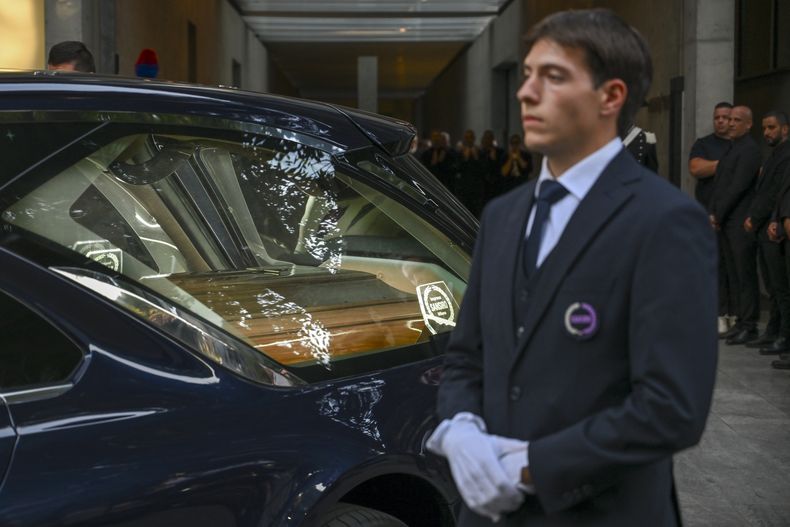 El personal de Giorgio Armani Spa se reúne afuera del Armani/Teatro en Milán, en el norte de Italia, mientras el coche fúnebre con el ataúd del diseñador Giorgio Armani, quien murió el jueves a los 91 años, parte el domingo 7 de septiembre de 2025. (Foto AP/Nicola Marfisi)