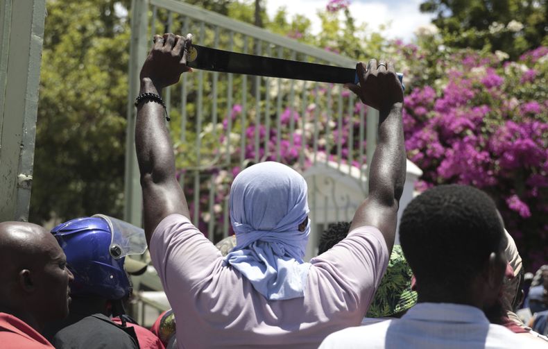 ARCHIVO - Un manifestante sostiene un machete como símbolo de autodefensa contra pandillas, en una protesta contra la violencia de pandillas en Puerto Príncipe, Haití, el viernes 25 de agosto de 2023. (AP Foto/Odelyn Joseph, archivo)