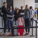 Marni Larsen y su hijo Damon Rasmussen, de Holladay, Utah, esperan en fila para recibir sus pasaportes en Los Ángeles el 14 de junio de 2023. (Foto AP /Damian Dovarganes)