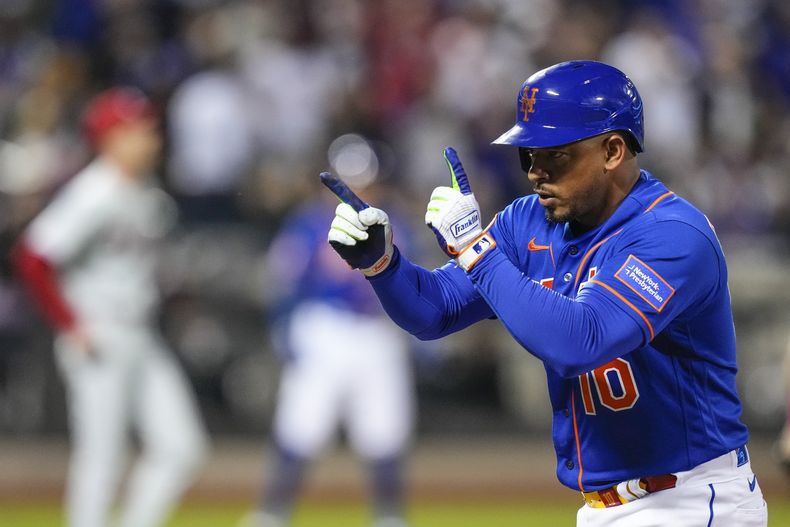 ARCHIVO - Eduardo Escobar, de los Mets de Nueva York, señala hacia sus compañeros de equipo después de producir carrera con un sencillo en contra de los Filis de Filadelfia durante la séptima entrada del juego de béisbol, el martes 30 de mayo de 2023, en Nueva York. Escobar fue intercambiado a los Angelinos de Los Ángeles por dos prospectos el viernes 23 de junio de 2023. (AP Foto/Frank Franklin II, Archivo)