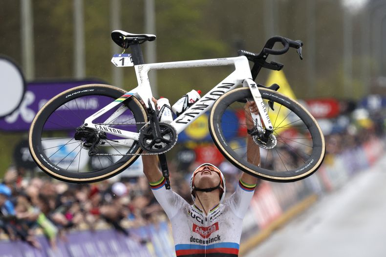 Mathieu van der Poel alza su bicicleta tras ganar el Tour de Flandes, el domingo 31 de marzo de 2024, en Oudenaarde, Bélgica. (AP Foto/Geert Vanden Wijngaert)