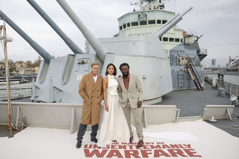 Cary Elwes, de izquierda a derecha, Eiza González y Babs Olusanmokun posan en el HMS Belfast en una sesión de la película The Ministry Of Ungentlemanly Warfare el viernes 22 de marzo de 2024 en Londres. (Foto Vianney Le Caer/Invision/AP)