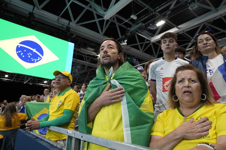 Aficionados cantan el himno nacional de Brasil antes de un juego de handball del país ante España en los Juegos Olímpicos de París 2024 el jueves 25 de julio del 2024. (AP Foto/Brian Inganga)