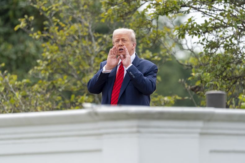 El presidente Donald Trump grita a los reporteros mientras inspecciona los terrenos desde el techo arriba de la columnata que va hacia el Ala Oeste de la Casa Blanca, el martes 5 de agosto de 2025, en Washington. (AP Foto/Alex Brandon)