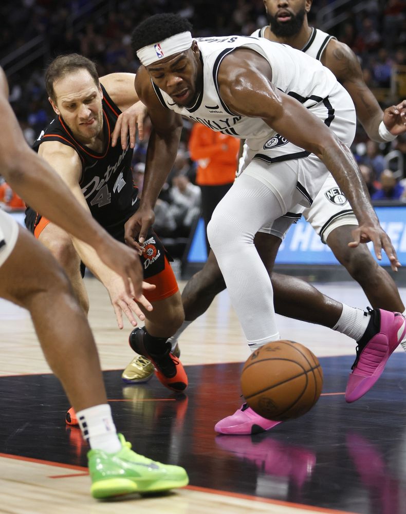 Bojan Bogdanovic (izquierda), de los Pistons de Detroit, y DeyRon Sharpe, de los Nets de Brooklyn, buscan un balón perdido durante el encuentro del martes 26 de diciembre de 2023 AP Foto/Duane Burleson)