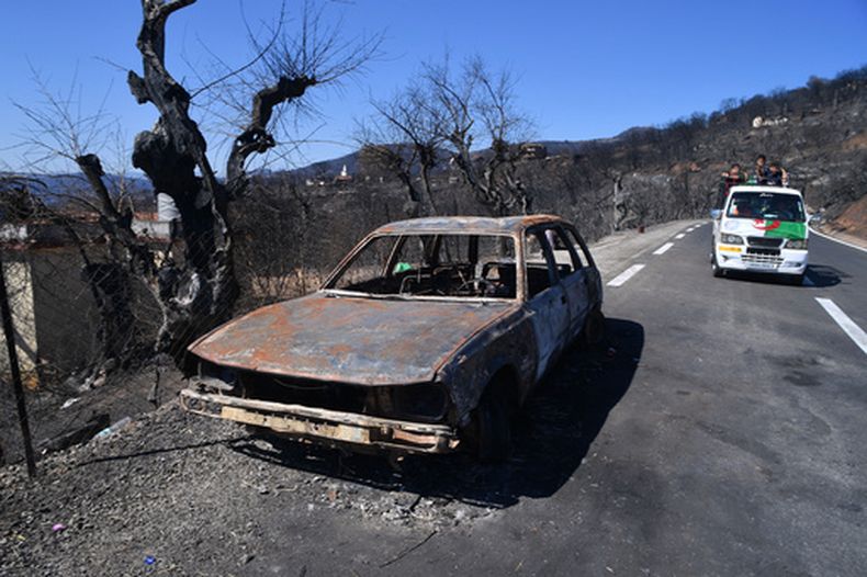Un auto calcinado, a un lado de la carretera luego de los incendios registrados en la localidad de Djemaa Beni Habibi, en Jijel, Argelia, el 4 de septiembre de 2026. (AP Foto/Fateh Guidoum)