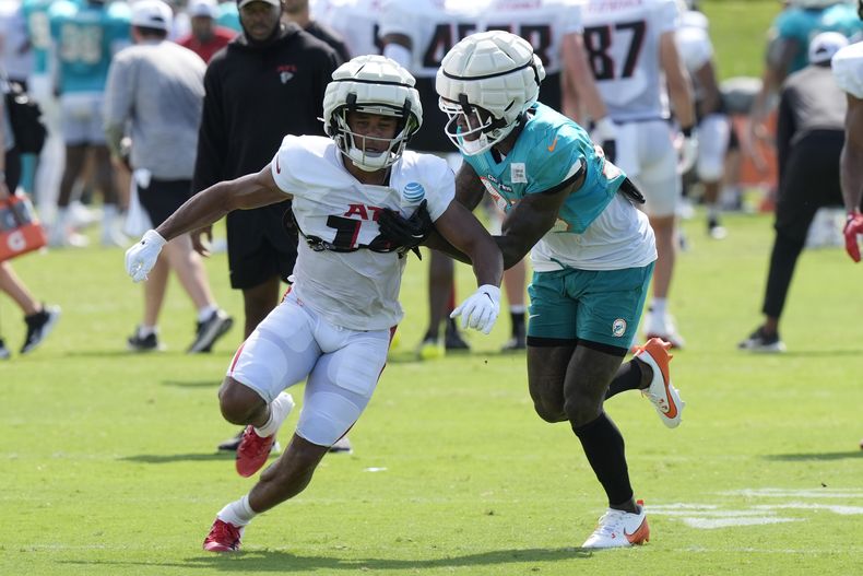 El esquinero de los Miami Dolphins, Siran Neal, defiende al receptor abierto de los Atlanta Falcons, Rondale Moore (14), durante una práctica conjunta de fútbol americano de la NFL en las instalaciones de práctica del equipo, el martes 6 de agosto de 2024, en Miami Gardens, Florida (AP Foto/Marta Lavandier)