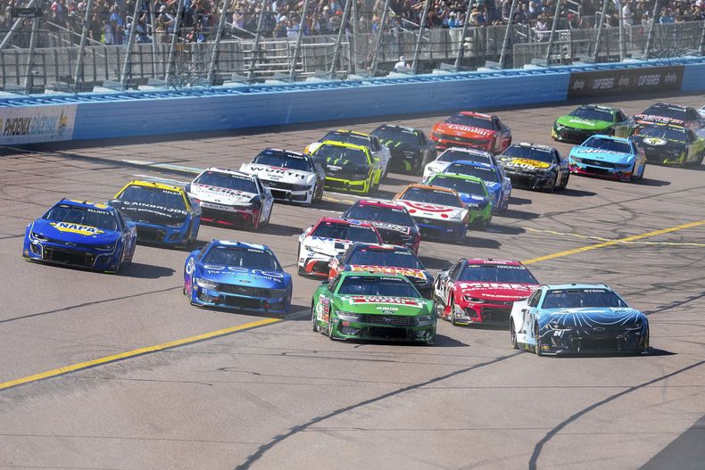 Los autos rodean la curva 4 para comenzar una carrera de autos de la NASCAR Cup Series en Phoenix Raceway, el domingo 9 de marzo de 2025, en Avondale, Arizona (AP Foto/Darryl Webb)