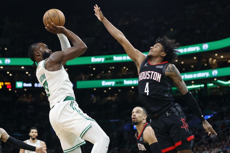 Jaylen Brown (7), de los Celtics de Boston, dispara contra Jalen Green (4), de los Rockets de Houston, durante la segunda mitad del partido de baloncesto de la NBA, el sábado 13 de enero de 2024, en Boston. (AP Foto/Michael Dwyer)