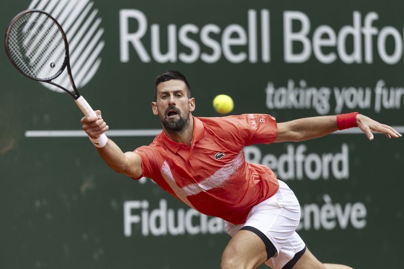 Novak Djokovic devuelve ante Marton Fucsovics en los octavos de final del Abierto de Ginebra, el miércoles 21 de mayo de 2025. (Cyril Zingaro/Keystone vía AP)