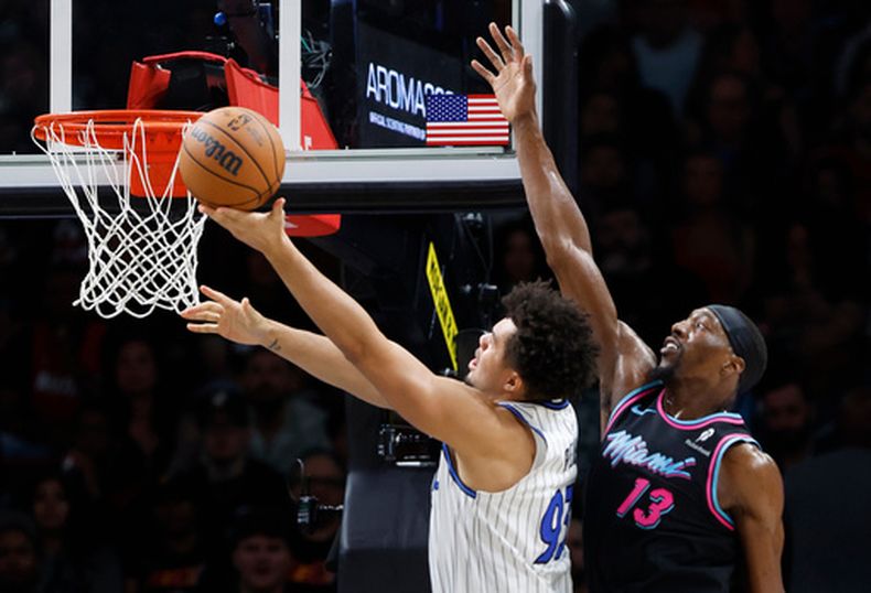 Noah Penda, alero del Magic de Orlando, dispara frente a Bam Adebayo, del Heat de Miami, el sábado 14 de marzo de 2026 (AP Foto/Rhona Wise)