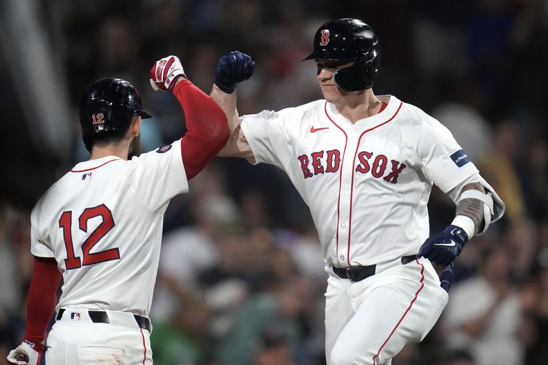 Tyler ONeill (derecha), de los Medias Rojas, es felicitado por Connor Wong (12) tras su jonrón solitario ante el lanzador de los Orioles de Baltimore, Cade Povich durante el tercer episodio del juego de béisbol en el Fenway Park, el lunes 9 de septiembre de 2024, en Boston. (AP Foto/Charles Krupa)