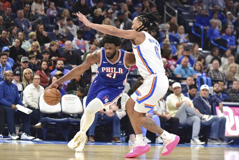 Joel Embiid, pívot de los 76ers de Filadelfia, elude a Jaylin Williams, del Thunder de Oklahoma City, en el encuentro del sábado 25 de noviembre de 2023 (AP Foto/Kyle Phillips)