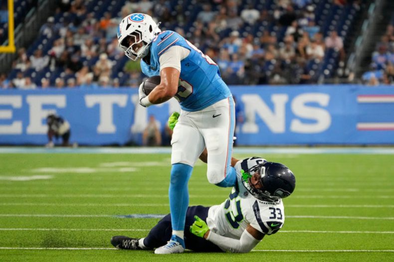 El tight end de los Titans de Tennessee Joel Wilson tacleado por el cornerback de los Seahawks de Seattle Jodan Washington en el encuentro de pretemporada el domingo 23 de agosto del 2026. (AP Foto/George Walker IV)